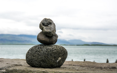 Fototapeta na wymiar Pyramid of stones for meditation background - coast in Icelans