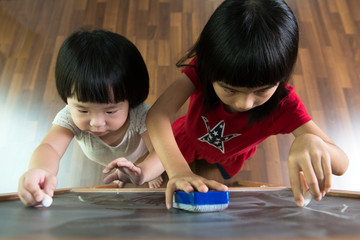 Two kids drawing on blackboard