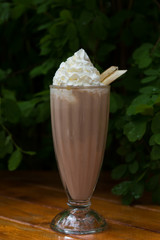 banana smoothie in a glass On a wooden background. banana cocktail