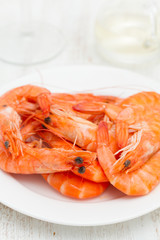 boiled shrimps on white dish on wooden background