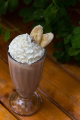 banana smoothie in a glass On a wooden background. banana cocktail. close up
