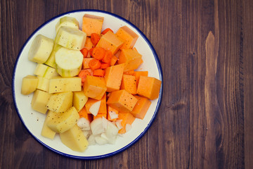 raw vegetables for soup on white plate
