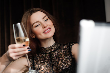 Woman in a restaurant relaxing with glass of champagne and tablet pc