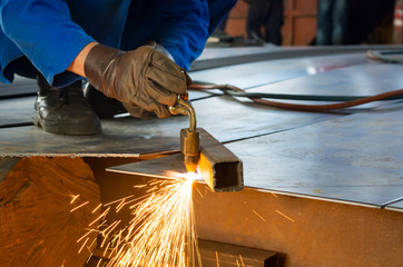 Man cutting metal with a welding cutting torch