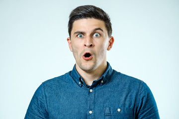 Portrait of young surprised man with opened mouth