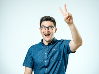 Fototapeta premium Happy man showing victory gesture