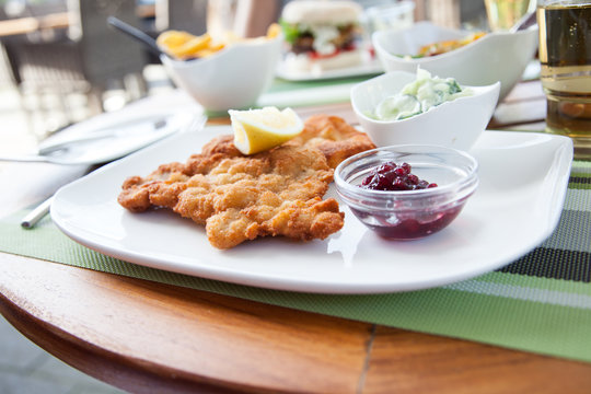 Wiener Schnitzel vom Kalb mit Gurkensalat auf Tisch