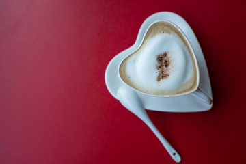 heart cup with coffee on the red table