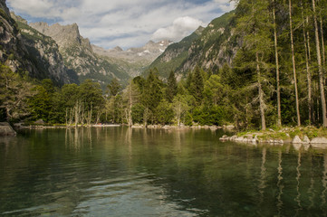 Fototapeta na wymiar Italia: il lago alpino della Val di Mello, una valle verde circondata da montagne di granito e boschi, ribattezzata la Yosemite Valley italiana dagli amanti della natura