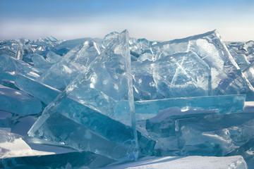 Transparent blue ice blocks on sky background in sunny frosty day, majestic winter landscape with hummocks