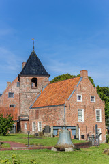 Fototapeta na wymiar Church tower and historic house in Greetsiel