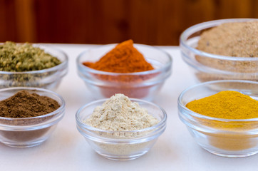 Different kind of colorful spices powder in glass bowls. Food and cuisine additives.
