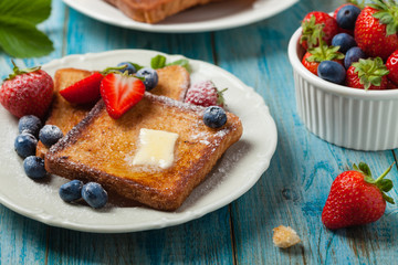 Traditional, delicious, sweet French toast with fruit and butter.