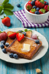 Traditional, delicious, sweet French toast with fruit and butter.