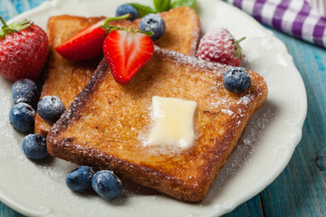 Traditional, delicious, sweet French toast with fruit and butter.