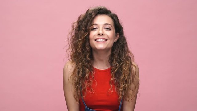 Young cheerful caucasian woman over pink background talking with you