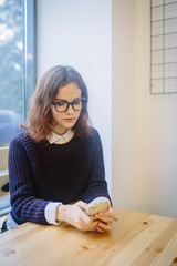 A nice and young girl writes on her mobile phone with a boyfriend, she smiles