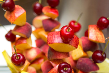 Cherry and peach on a stick. Fruit on a stick on a banquet table