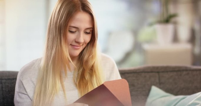 Young attractive caucasian woman receiving letter and smiling for joy