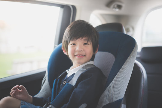 Portrait of cute Asian child sitting in car seat