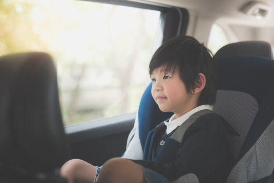 Portrait of cute Asian child sitting in car seat