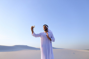 Portrait of Arabian sheikh man with gadget that communicates in 