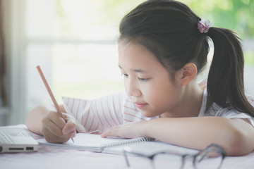 Beautiful asian girl writing to diary