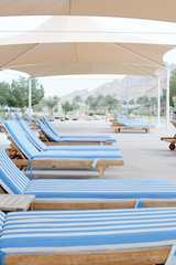Swimming pool and deck chairs at the resort. United Arab Emirates