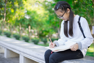 young students thinking and writing in notebook