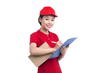 Beautiful young delivery woman in red t-shirt and cap smiling, holding a folder and making notes, on white background