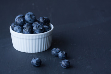 blueberry in a bowl on a black background