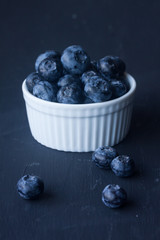 blueberry in a bowl on a black background