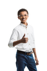 portrait of smiling african american teenager in eyeglasses showing thumb up isolated on white