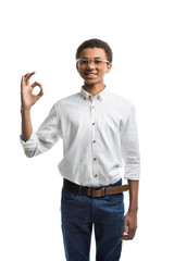 smiling african american teenager showing ok sign isolated on white