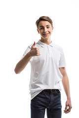 portrait of smiling caucasian teenager showing thumb up while looking at camera isolated on white