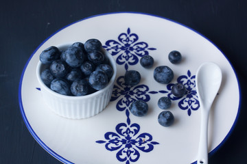 Blueberry in a plate on a black background
