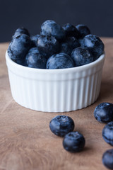 Blueberry in a bowl on a wood background
