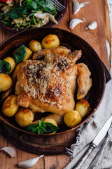 Whole roasted chicken with potatoes on dinner table