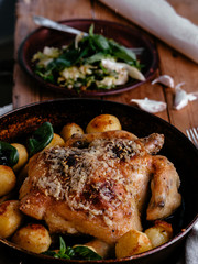 Whole roasted chicken with potatoes on dinner table
