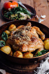 Whole roasted chicken with potatoes on dinner table
