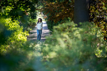 Naklejka na ściany i meble girl is walking alone in the park