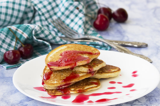 Homemade pancakes with cherry syrup.