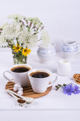Cup of coffee tea chicory drink hot beverage  with chicory flower and sugar cookies on a white table.  Still life with breakfast