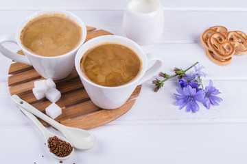 Medicinal plant chicory, Diet drink chicory in a cup with milk for breakfast on a white table.