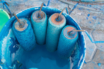 Paint roller brush at the bucket with blue paint © Phuri