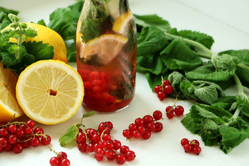Drink of mint, lemon and red currant in bottle of glass with straw. between in Ingredients