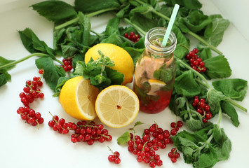 Drink of mint, lemon and red currant in bottle of glass with straw. between in Ingredients