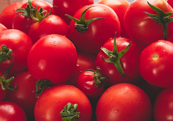 A side view, 45 degree angle view of a tray of bright red ripe tomatoes.