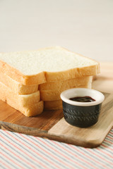 sliced plain bread and jam on wooden tray