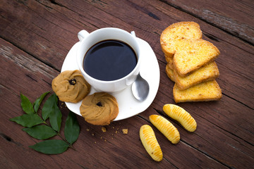 Coffee cup and cookie on wood